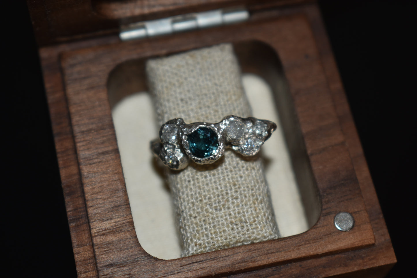 Silver ring in a wooden ring box.