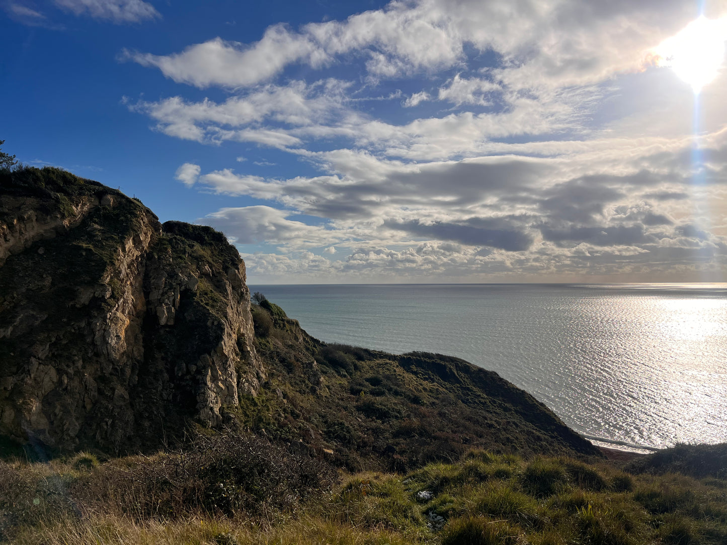 Rugged coastline with cliffs and ocean under a blue sky. St Ives, Cornwall. Shem Hake Jewellery.