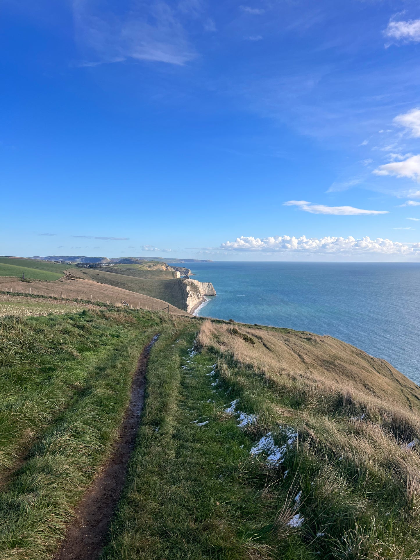 Path leading to a coastal cliff with blue sky and ocean view. Swanage.