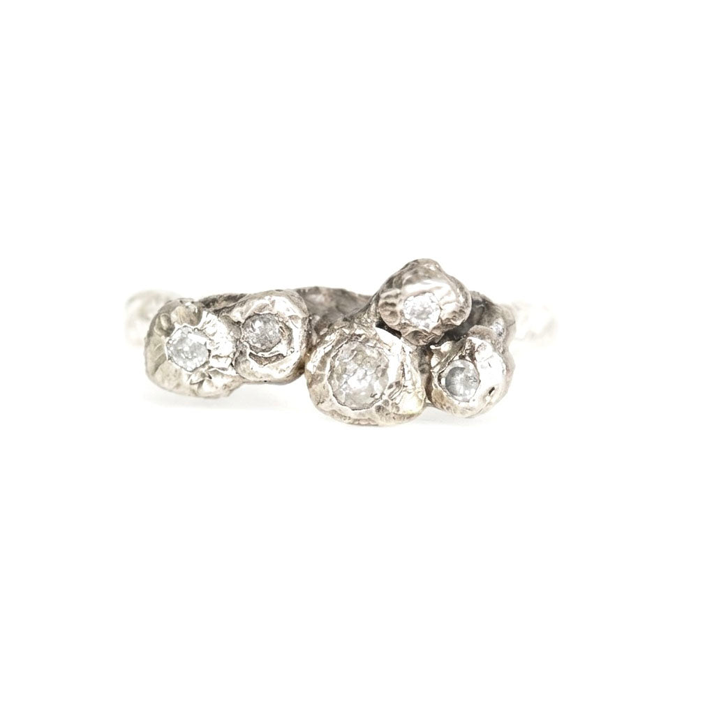 Silver ring with multiple diamonds on a white background