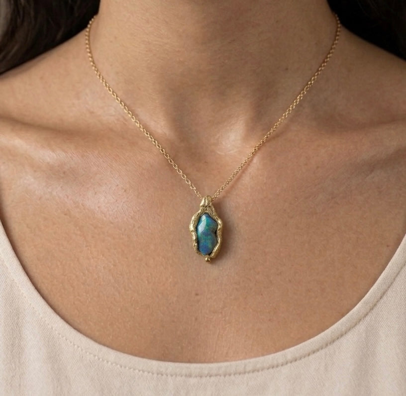 Necklace with a pendant featuring a blue stone worn by a person. Jewellery made on Cornish beaches. 