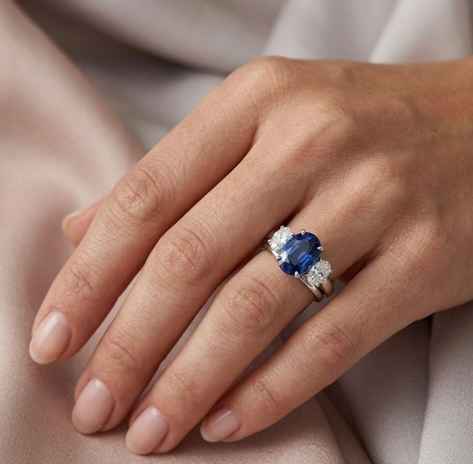 Trilogy engagement ring, sapphire and dianond. On a women’s hand. Part made in The Peak District. Shem Hake Jewellery. 