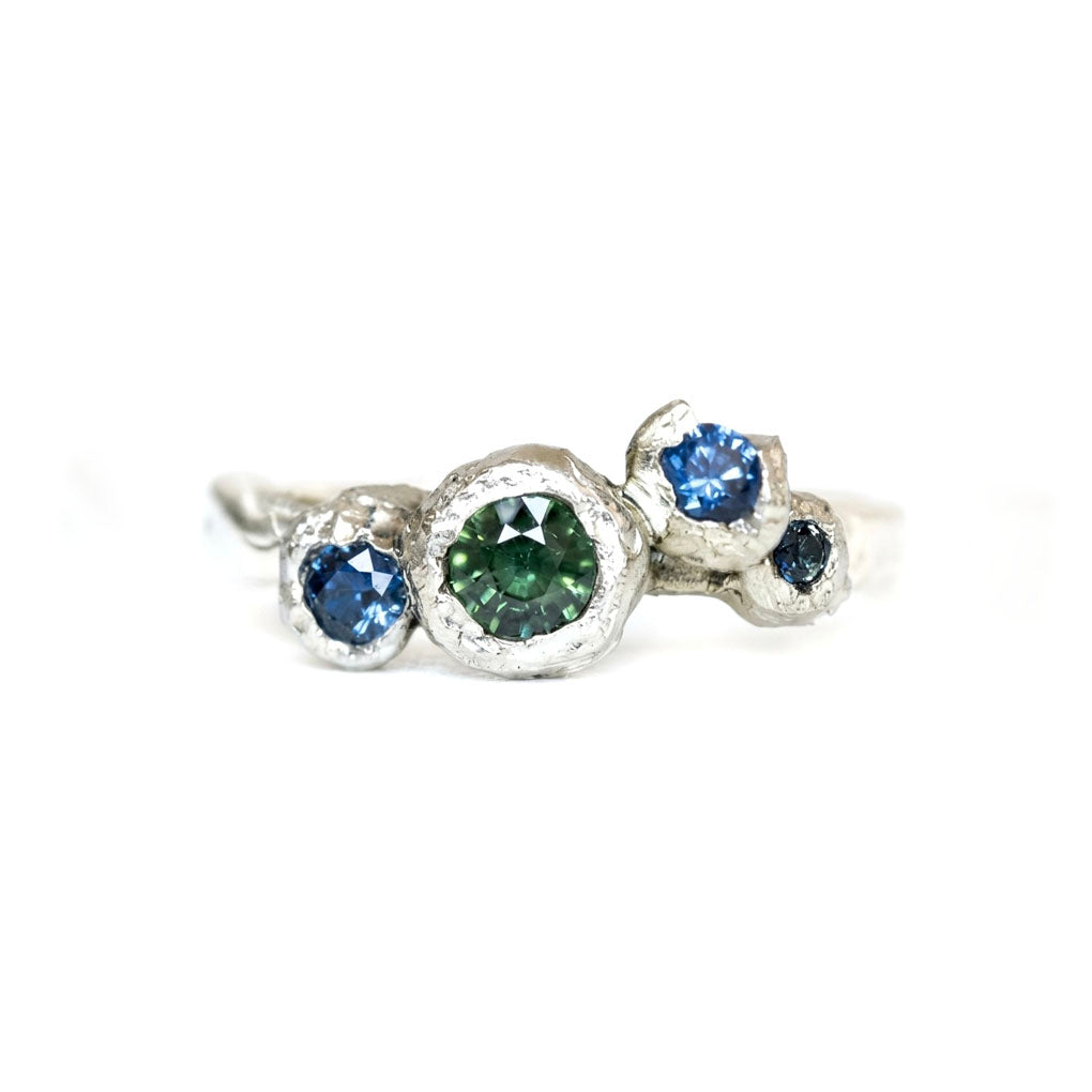 Silver ring with three coloured Sapphires on a white background