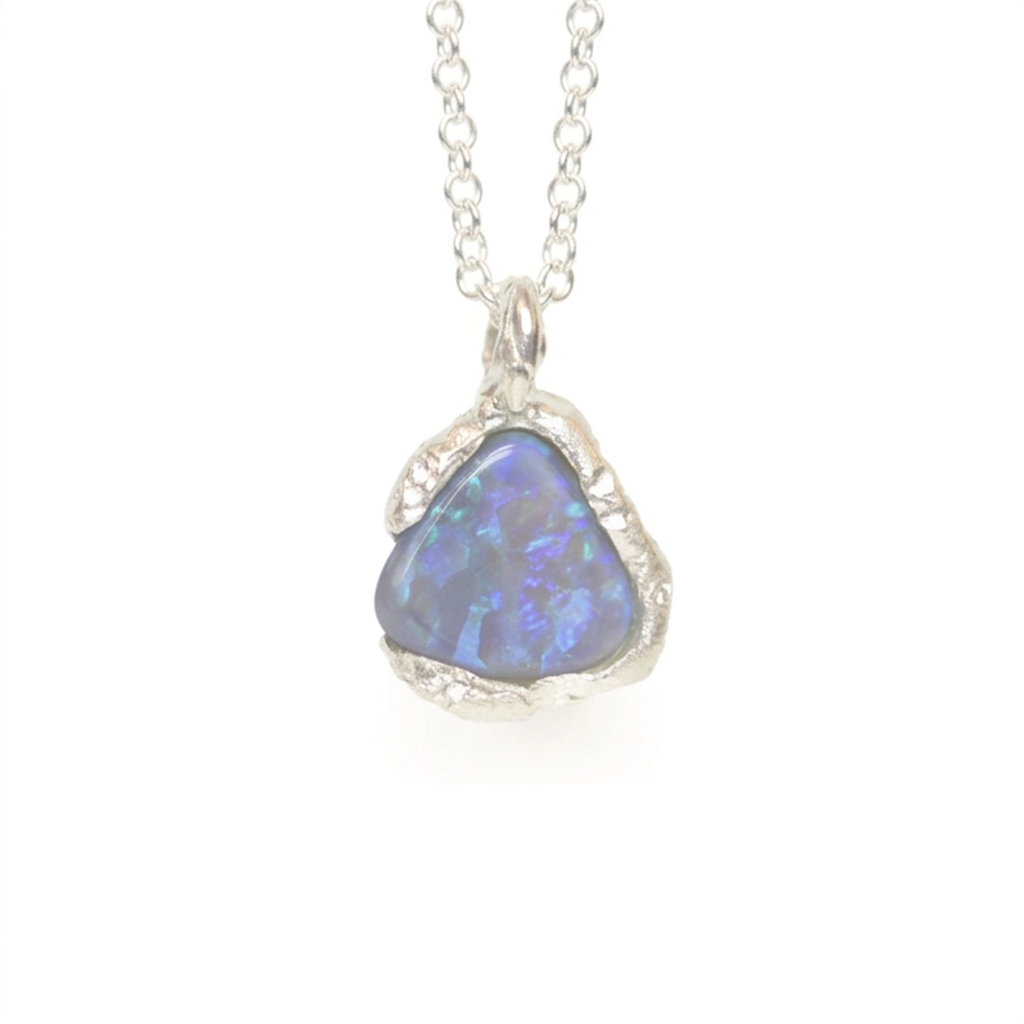 Triangular opal pendant on a silver chain against a white background. Jewellery made in the highlands of Scotland, on the summit of Ben Lomond. 