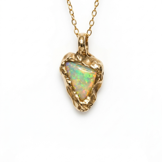 Gold necklace with a heart-shaped opal pendant on a white background. Jewellery made in Cornwall, Lizard point. 